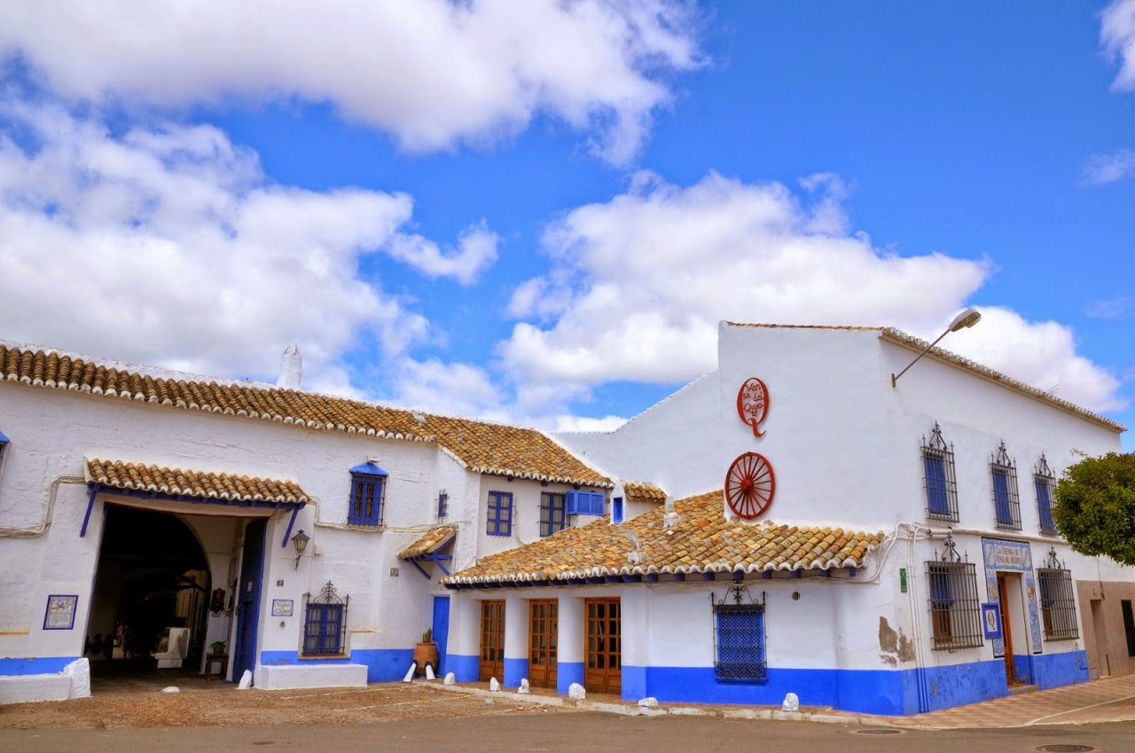 Casa encalada de zócalos y ventanas azules en la Mancha (España).
