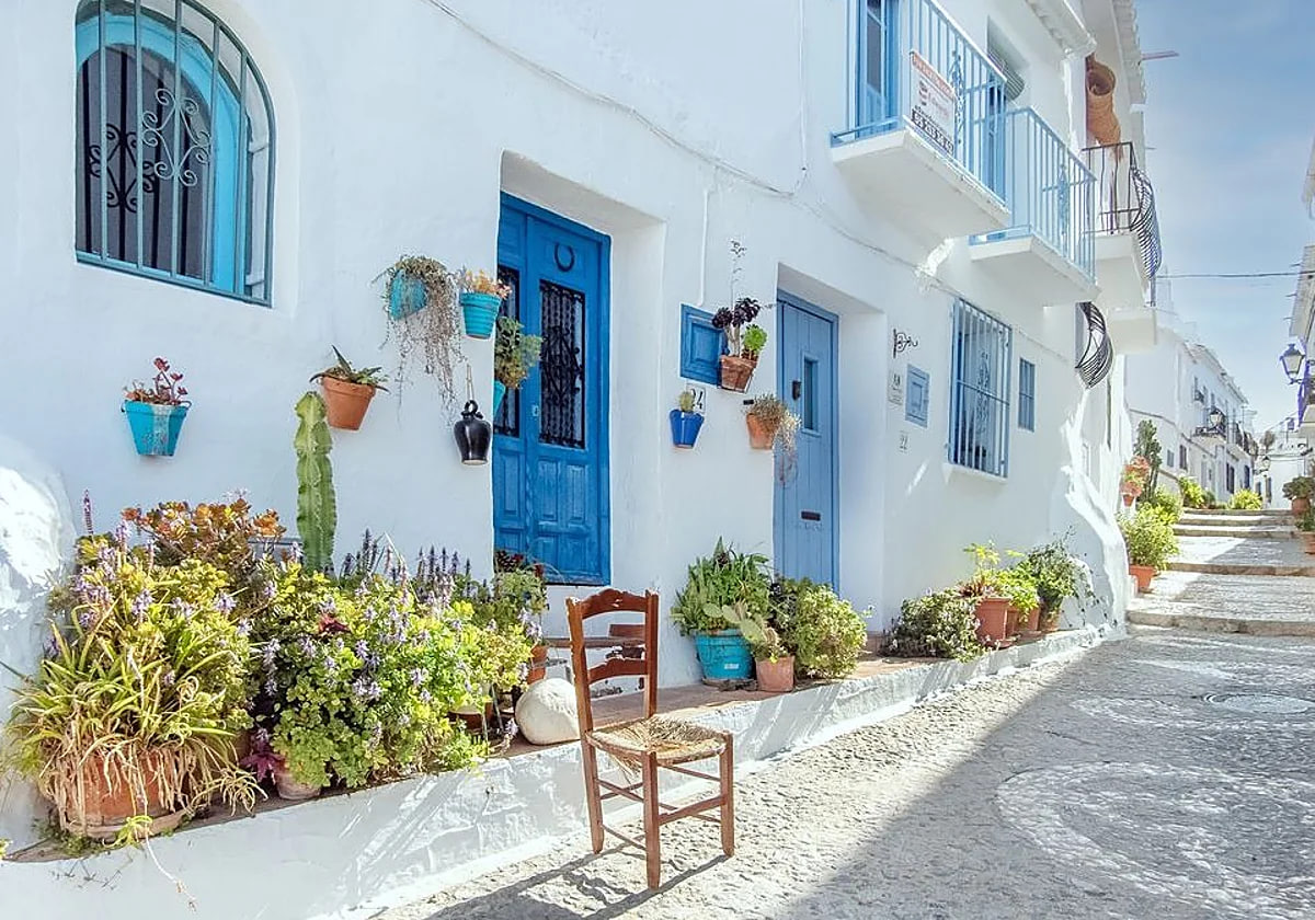Casa encalada de zócalos y ventanas azules en Andalucía (España).